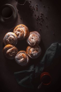 Encaimadas İspanyol çörekleri masanın üstünde, siyah arkaplanda en üstte.