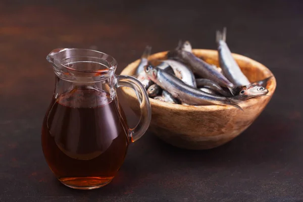 Molho de peixe Garum feito de anchovas no fundo escuro — Fotografia de Stock