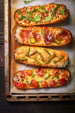 Peynirli pizza dilimleri ve salam, jambon gibi malzemeler. Üst görünüm, kırsal biçim