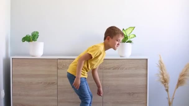 穿着黄色T恤和牛仔裤的男孩在家里跳舞 — 图库视频影像