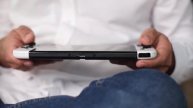 Beyaz gömlekli adam video oyunu konsolu oynuyor