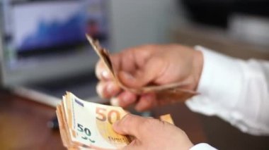 Ofis geçmişinde euro banknotlarını sayan adam
