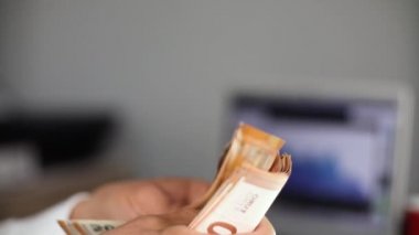 Ofis geçmişinde euro banknotlarını sayan adam