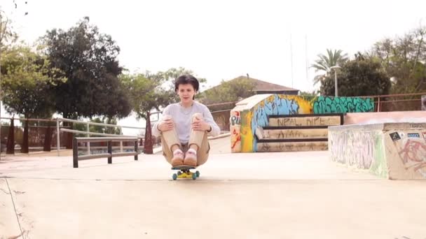 Teenage girl rides sitting on a skateboard — Stock Video