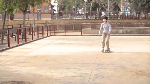 Девочка-подросток катается на скейтборде в пустом скейтпарке — стоковое видео