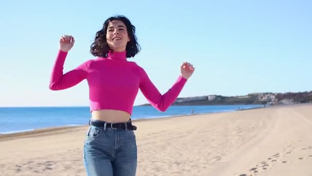Νεαρή γυναίκα χορεύει μόνη στην παραλία και γελάει — Αρχείο Βίντεο