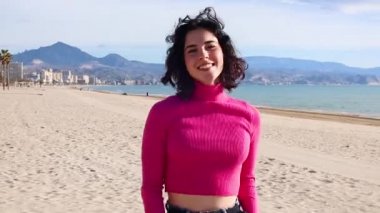 Genç bir kadın kıyıya çıkıyor ve gülüyor.