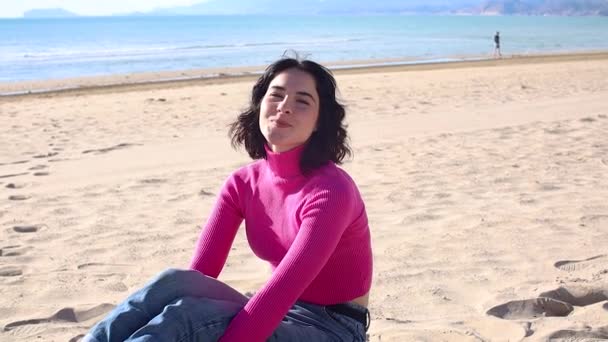 Jeune femme souriant sur la plage sur fond de paysage marin — Video