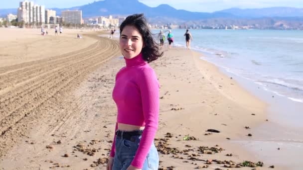 Mujer joven vestida recorre la costa y sonríe — Vídeo de stock