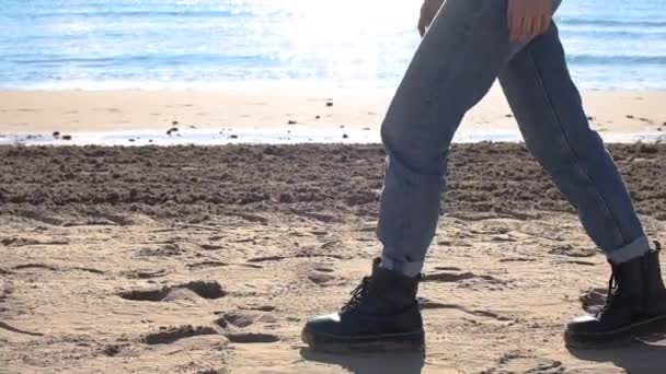 Young woman in boots goes along the coastline — Wideo stockowe