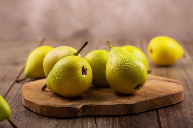 Kesme tahtasında su damlaları olan armutlar