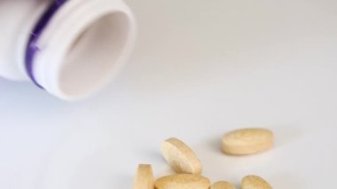 Haplar plastik bir kavanozdan beyaz bir masaya döküldü. Yüksek kaliteli FullHD görüntüler