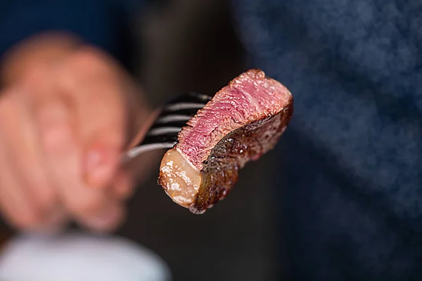 Uomo Tiene Pezzo Bistecca Mediamente Rara Una Forchetta Foto Alta — Foto Stock