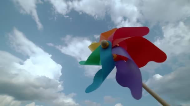 Kolorowa śruba papierowa obraca się przeciwko błękitnemu niebu, zwolniony ruch — Wideo stockowe