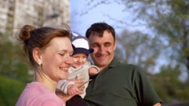 Güneşli bir günde mutlu bir aile, anne, baba ve oğul yürüyüşü.