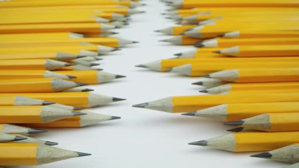 Lápices amarillos se encuentran al azar sobre un fondo blanco — Vídeo de stock