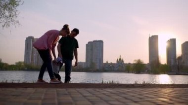 Genç anne ve baba çocuğa yol boyunca yürümeyi öğretir.