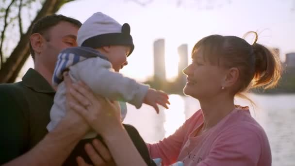 Il padre tiene il suo figlioletto tra le braccia. Mamma bacia il bambino. — Video Stock