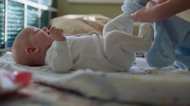 Annenin elleri küçük bir çocuğu giydirir..