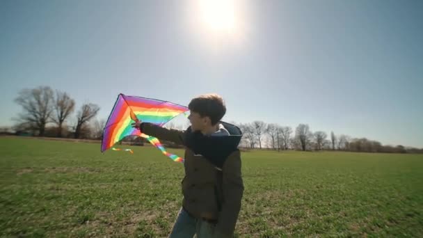 A happy boy is playing with a flying rainbow kite. — Video Stock