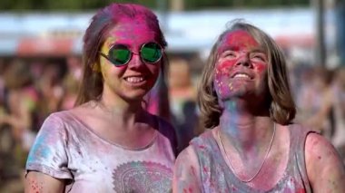 Holi Festivali 'nde renkli boyaları tutan ve püskürten mutlu kızlar..