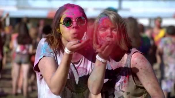 Ευτυχισμένα κορίτσια που κρατούν και ψεκάζουν πολύχρωμες μπογιές στο Holi festival. — Αρχείο Βίντεο