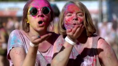 Mutlu kızlar ellerinde renkli boya tutarlar Holi festivalinde kameraya toz üflerler. Çok komik. Festival.