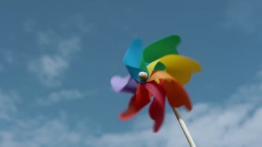 renkli kağıt vida mavi bir gökyüzü üzerinde döner, yavaş çekim.