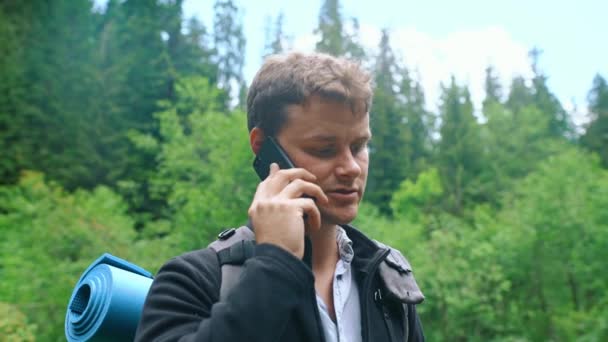 Ung Man Med Ryggsäck Står Skogen Och Pratar Mobiltelefon Stilig — Stockvideo