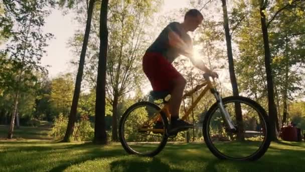 Ποδηλάτης Εκτελεί Ένα Τέχνασμα Ένα Φόντο Των Δέντρων Ποδηλάτης Αργή — Αρχείο Βίντεο