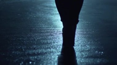 Büyük bir şehrin sokaklarında gece vakti arka planda yürüyen bir adamın bacakları. Bir yayaydı. Hotba. Şehir hayatı. Arka plan