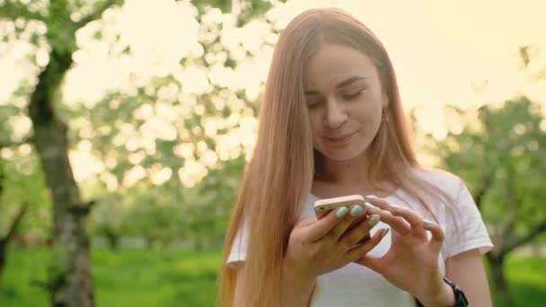 Retrato Una Hermosa Mujer Escribiendo Teléfono Móvil Parque Chica Sostiene — Vídeos de Stock