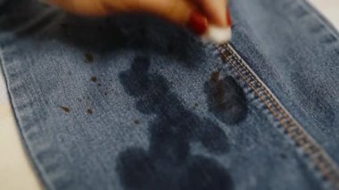 Bir kadın özel bir aletle pantolonunu lekelerden temizler. Temizlik kıyafetleri konsepti.