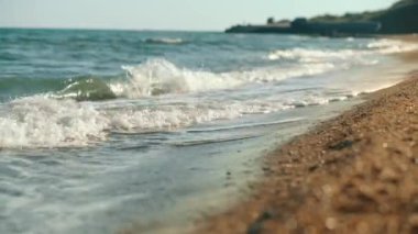 Close-up of sea waves washing over a sandy beach. Calming waves of the beach