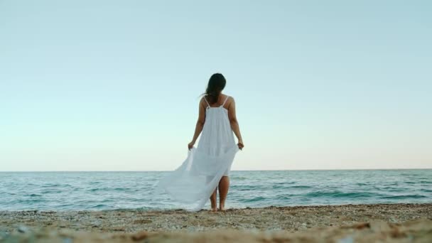 Young Girl White Dress Stands Alone Seashore Looks Distance She — Video Stock