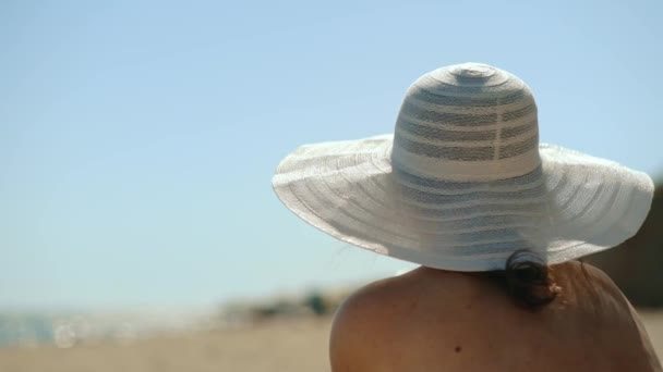 Young Girl White Hat Sits Seashore Looks Distance Portrait Attractive — Vídeos de Stock