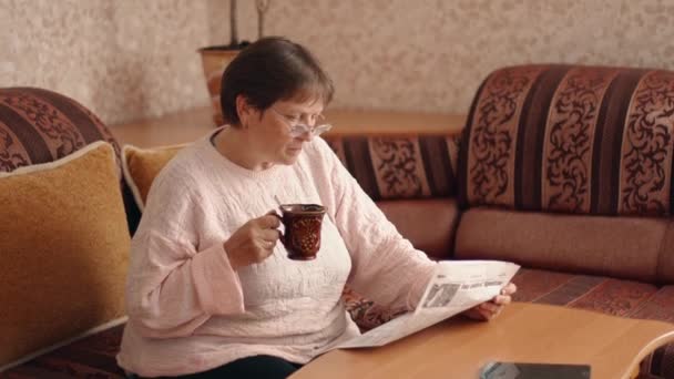 Pretty Middle Aged Woman Glasses Reading Newspaper Drinks Tea Coffee — Vídeo de Stock