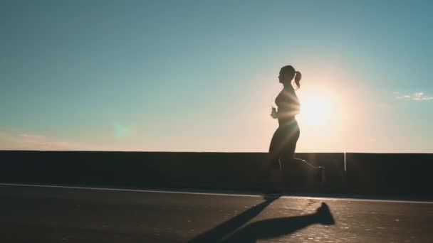 Silhouette Girl Jogging Road Rays Setting Sun Side View High — Stockvideo