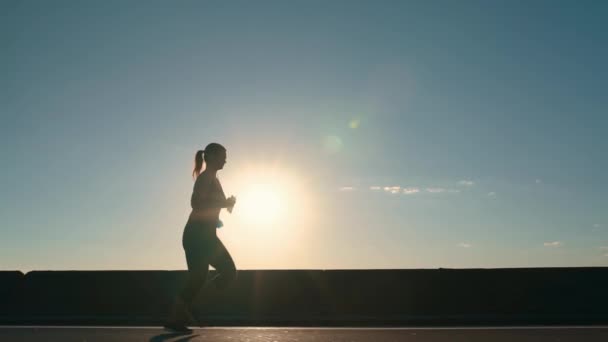 Silhouette Girl Jogging Road Rays Setting Sun Side View High — Stockvideo