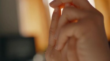 A young girl caresses her tender hands in the rays of the sun in the room. Womens hands close up. Hand massage after waking up. High quality 4k footage