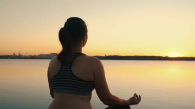 Silhouette of young woman practicing yoga on the nature at sunset. active meditation a relax concept. woman meditation in nature. High quality 4k footage