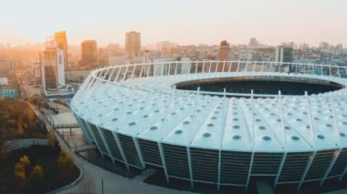 UKRAINE, KYIV - 12 April 2020: National Sports Complex Olympiyskiy. Birds eye view of the football stadium and cityscape. Side view. High quality 4k footage