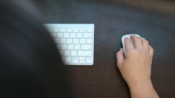 女性は マウスとキーボードを操作する木製のテーブル上のコンピュータで動作します 女性サラリーマンが彼女と一緒にページをスクロールします 高品質4K映像 — ストック動画