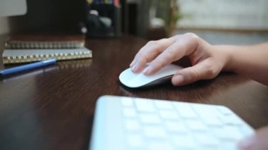 İş yerine yakın çekim. Beyaz bir bilgisayar faresiyle tıklama. Kız bilgisayarda çalışıyor ve teknolojiyle etkileşim kurmak için yepyeni bir cihaz kullanıyor.