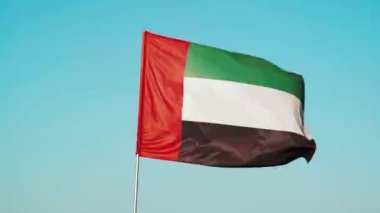 Bayrak direğindeki Birleşik Arap Emirlikleri bayrağı rüzgarda dalgalanır. BAE 'nin ulusal bayrağı. Dubai işareti kusursuz döngü animasyonu. Yüksek kalite 4k görüntü
