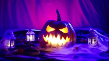 İçi ışık saçan, kötü huylu bir balkabağı. Cadılar Bayramı kutlamaları sırasında balkabağı feneri. Azizler Günü kutlamalarının atmosferi. Yüksek kalite 4K görüntü.