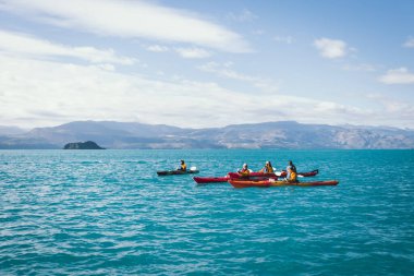 Puerto Tranquilo, Şili - 31 Ocak 2022: Kayakçılar açık bir yaz gününde göl boyunca kürek çekerler