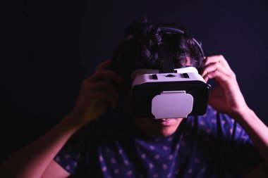 Sanal gerçeklik VR kulaklık kullanan genç latin adam. Stüdyo karanlık fon. Alçakgönüllülük. Boşluğu kopyala