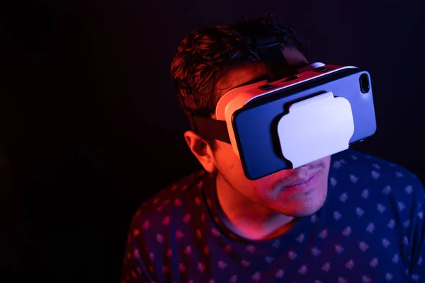 Virtuális valóság VR headset 3D szemüveget használó fiatal latin férfi. Stúdió sötét háttér. Alacsony kulcs. — Stock Fotó