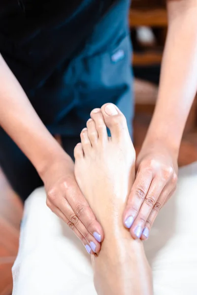 Terapeuta irreconocible haciendo un masaje de pies a una paciente femenina. Spa centro de bienestar. Cuidado de los pies. —  Fotos de Stock